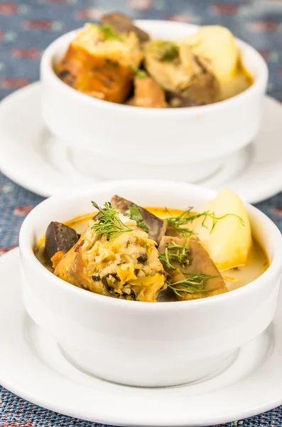 테이블, 블루 식탁보, 아늑한 레스토랑 배경에 앉아 흰 그릇에 고기와 야채, 감자 수프의 고급 서비스 제공 — 스톡 사진