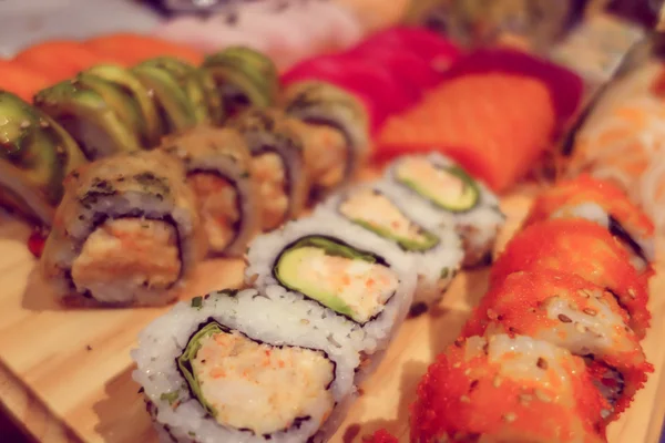 Primer plano elegante surtido de rollos de sushi alineados, como se ve desde el ángulo lateral superior — Foto de Stock