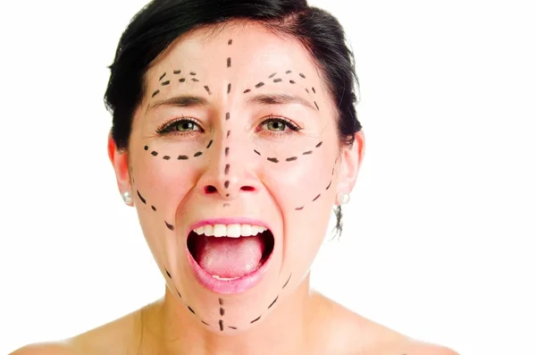 Крупный план кавказская женщина с пунктирными линиями вокруг лица, смотрящая в камеру, готовясь к косметической операции, крича выражение лица — стоковое фото