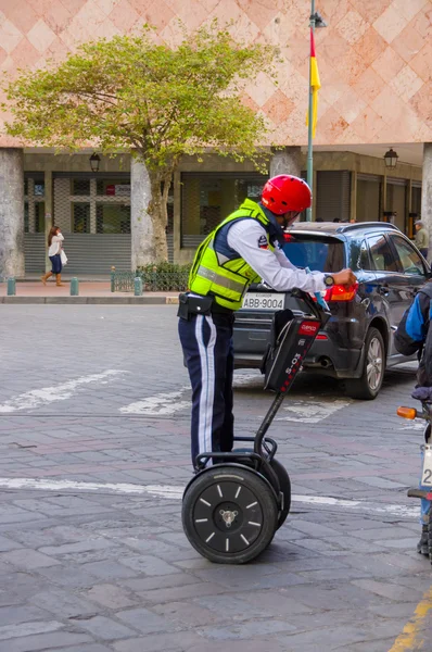 Cuenca, Equador - 22 de abril de 2015: Policial vestindo capacete vermelho em Segway durante serviço de patrulha da cidade — Fotografia de Stock