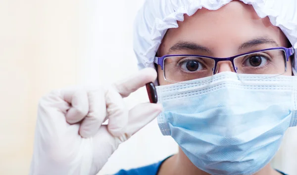 Closeup headshot verpleegkundige dragen bouffant GLB en gezichtsmasker bedrijf in twee capsules van de pil voor camera — Stockfoto