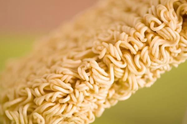 Closeup uncoked noodle block with blurry background — Stock Photo, Image