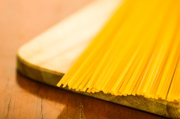 Closeup stapel van droge spaghetti, gele kleur en uitvoerig — Stockfoto