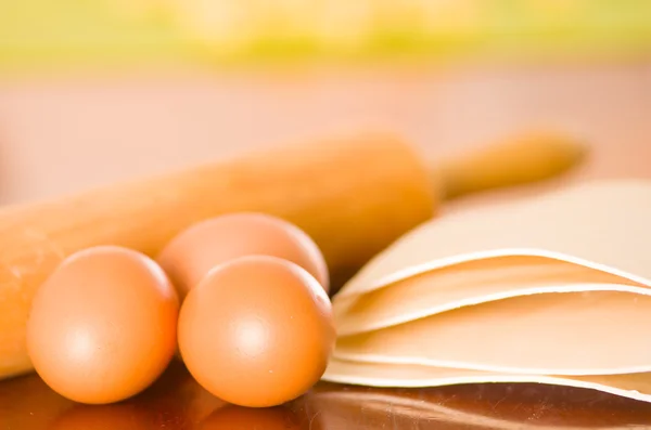 Скалка, яйца, макароны и тесто, разбросанные по деревянной поверхности — стоковое фото