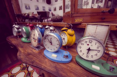 Cuenca, Ecuador - April 22, 2015: Old colourful vintage alarm clocks found inside typical local pawn shop clipart