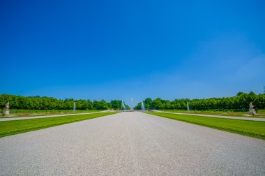Schleissheim, Almanya - 30 Temmuz 2015: Royal garden palace özelliği inanılmaz organize yeşil çalılar ve çakıl yollarda, görkemli tasarım, güzel mavi gökyüzü ile
