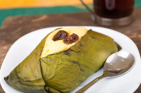 Lahodné sladké drsné s rozinkami zabalené v achira leaf podává na bílé misce, quimbolito — Stock fotografie