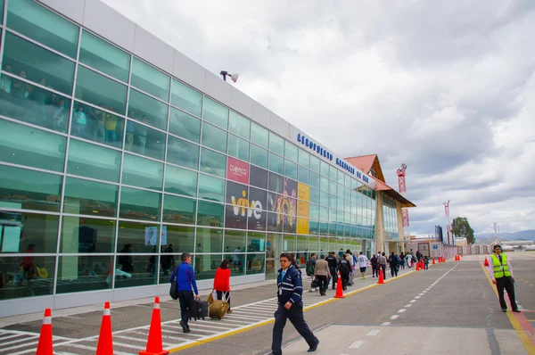 Cuenca, Ecuador - 22 de abril de 2015: Pasajeros que ingresan al edificio de la terminal aeroportuaria desde la zona de pista, conos rojos y marcas en la superficie — Foto de Stock