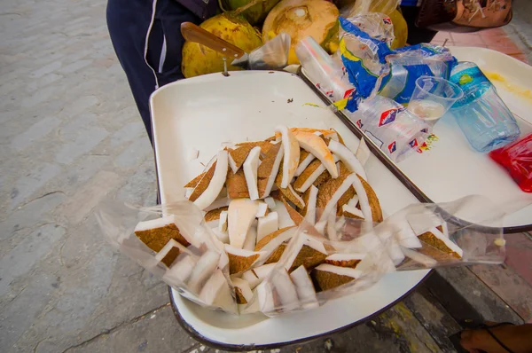 Cuenca, Ecuador - 22 April 2015: Segmenten van kokosnoot liggend op de lade op straatverkoper winkel te koop — Stockfoto