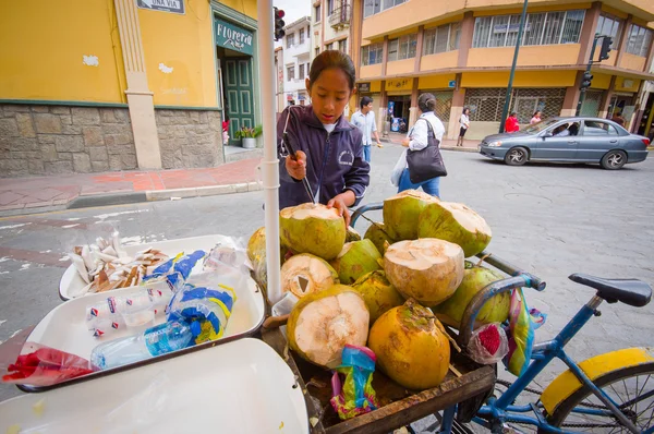 Cuenca, Ecuador - 22 de abril de 2015: Joven adolescente que trabaja en una tienda de bicicletas de coco en el centro de la ciudad, sosteniendo un cuchillo que lo usa para trabajar —  Fotos de Stock