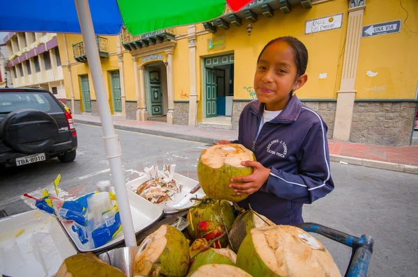 Cuenca, Ecuador - 22 April 2015: Ung tonårsflicka arbetar på kokos cykelaffär i centrum, leende till kamera — Stockfoto