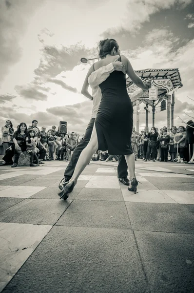 Cuenca, Ecuador - 22 de abril de 2015: Pareja interpretando estilos de baile latino en la plaza de la ciudad frente a una pequeña multitud, edición en blanco y negro — Foto de Stock