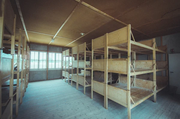 Dachau, Germany - July 30, 2015: Inside sleeping quarters with wooden bunk beds showing prisoners terrible living conditions — Stock Photo, Image