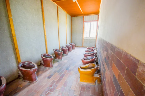 ダッハウ、ドイツ - 7月 30、2015:バスルーム内には、すべての囚人が強制収容所で使用するために行にインストールされている多くのトイレがあります — ストック写真