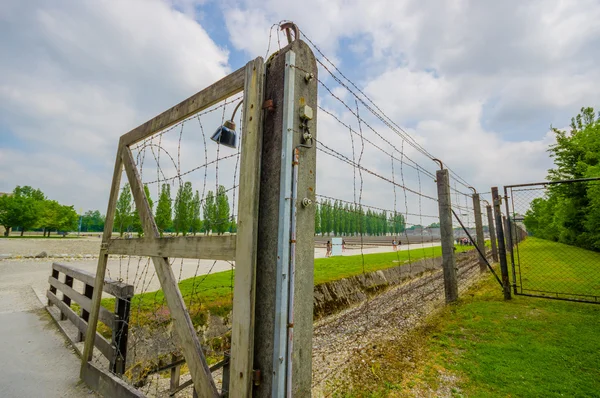 Dachau, Duitsland - 30 juli 2015: Eenvoudige poort naast prikkeldraad hek bouwstijl concentratiekamp — Stockfoto