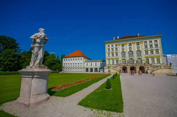 Nymphenburg, Γερμανία - Ιούλης 30, 2015: Όμορφο παλάτι όπως φαίνεται από απόσταση με αγάλματα στις δύο πλευρές της λεωφόρου που οδηγεί σε κτίριο — Φωτογραφία Αρχείου