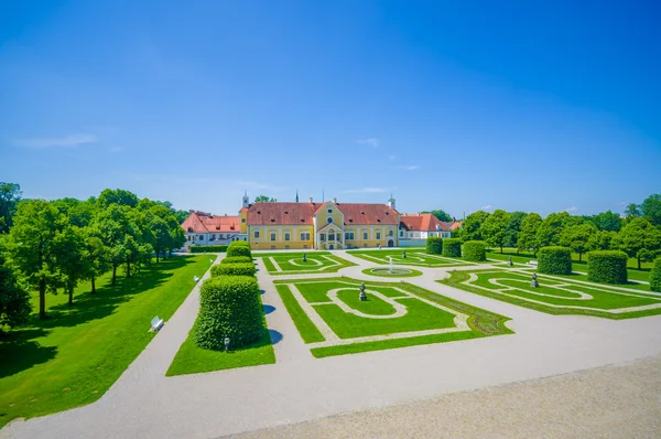 Schleißheim, Deutschland - 30. Juli 2015: königlicher Garten des Palastgrundstücks mit unglaublich geordneten grünen Büschen und Schotterwegen, majestätisches Design, wunderschöner blauer Himmel — Stockfoto