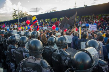 Quito, Ekvator - 7 Nisan 2016: anti Shyris Avenue, güzel mavi gökyüzü ve binaların arka plan hükümet Protesto huzurlu bakan bekleyen polis