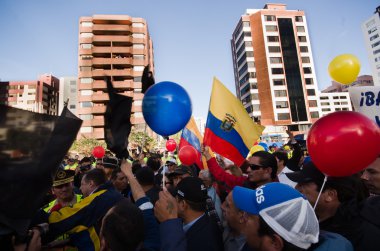 Quito, Ekvator - 7 Nisan 2016: Grup insanlar Holding protesto işaretler, polis ve anti Shyris Avenue hükümet protesto sırasında gazeteciler ile balonlar
