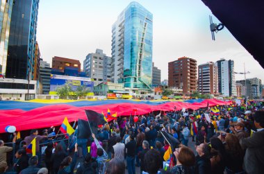 Quito, Ekvator - 7 Nisan 2016: Bir grup insan bir çok büyük Ekvador bayrak, protesto ve hükümet protesto anti sırasında gazeteciler Shyris caddede görüntüleme.