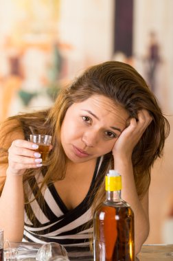 Genç esmer üzgün ve yorgun bir kadeh alkol, Resepsiyon önünde şişesinde gidiyor seyir oturarak,