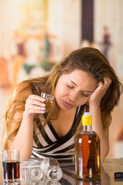 Genç esmer üzgün ve yorgun bir kadeh alkol, Resepsiyon önünde şişesinde gidiyor seyir oturarak,