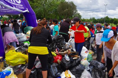 Quito, Ekvator - Nisan, 17, 2016: Afet Yardım gıda, giyim, ilaç ve su kıyılarında deprem kurtulanlar için sağlayan tanımlanamayan vatandaşlar Quito