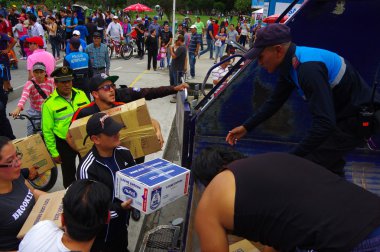 Quito, Ekvator - Nisan, 17, 2016: Afet Yardım gıda, giyim, ilaç ve su kıyılarında deprem kurtulanlar için sağlayan tanımlanamayan vatandaşlar Quito