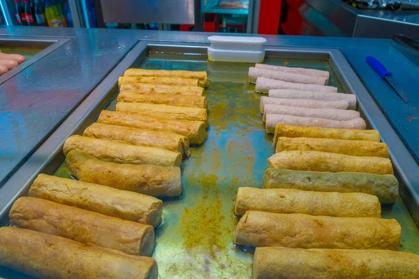 Delicioso frito rolado massa de farinha, vários em um ferro metálico grelhado — Fotografia de Stock