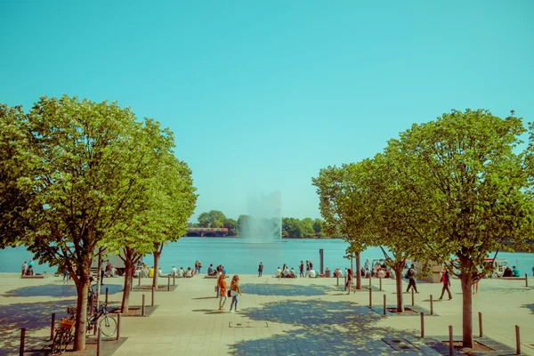 Hamburg, Almanya - 08 Haziran 2015: ortasında ağaç bir kaldırım su sıçrama, Hamburg Gölü cazibe biter