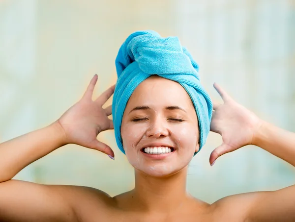 Pretty young healthy hispanic woman headshot with naked shoulders, blue towel wrapped around head, posing happily, creamy hands and eyes closed — Stock Photo, Image