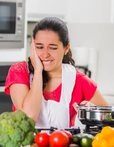 Junge Köchin kocht mit skeptischer Mimik, interagiert mit frustrierter Körpersprache — Stockfoto