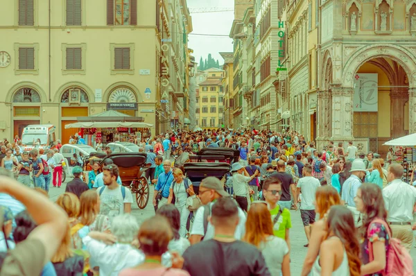 Florence, Olaszország-június 12, 2015: különböző emberek járkálni egy négyzet Firenzében, fa szekerek a végén a vonzás, fejek csak — Stock Fotó