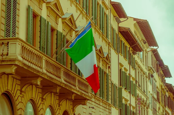 FLORENCE, ITALY - JUNE 12, 2015: Italy flag on Florence historic building, opened windows — стокове фото