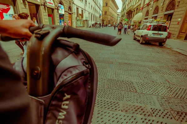 Florenz, Italien - 12. Juni 2015: Fahrradlenker mit einer Hand in Nahaufnahme, davor Stein und alte Straße. Autos auf den Seiten — Stockfoto