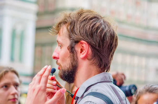 FLORENCE, ITALY - JUNE 12, 2015: Italian tour guide close up, microphone speaking for a group — Stock fotografie