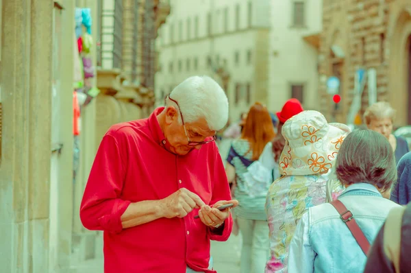 Firenze, Olaszország - 2015. június 12.: Azonosítatlan öreg ember keres, elég koncentrációja a mobiltelefonra — Stock Fotó