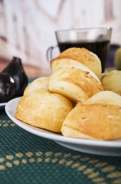 Fresh bread buns piled up, elegant white plate sitting on green table cloth, restaurant bakery concept — Stock Photo, Image