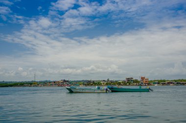 Muisne, Ekvator - 16 Mart 2016: birlikte denizde bağlı geleneksel balıkçı tekneleri, şehir arka plan ve güzel mavi gökyüzü