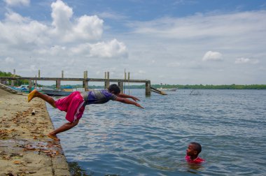 Muisne, Ekvator - 16 Mart 2016: dalış ve Pasifik Okyanusu'nda giysileri ile taş yüzey üzerinden üzerinde Yüzme çocuklar