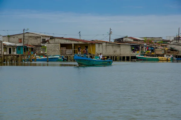 Muisne, Ecuador - March 16, 2016: Muisne town as seen from water, modest wooden houses sitting on poles waterfront pacific ocean, city buildings background and beautiful blue sky — Stock Photo, Image