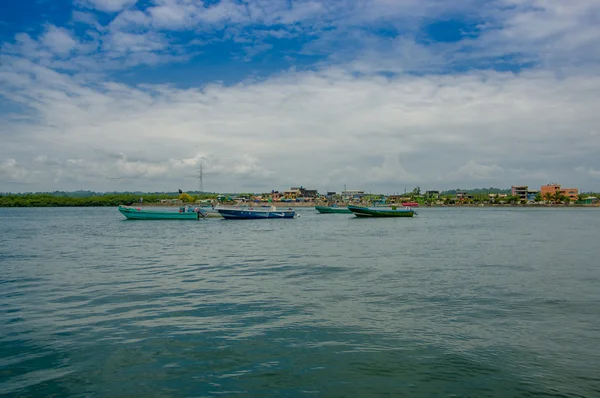 Muisne, Ecuador - 16 maart 2016: Traditionele vissersboten op zee samengebonden, stad in de achtergrond en een mooie blauwe hemel — Stockfoto