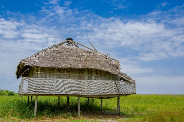 Muisne, Équateur - 16 mars 2016 : Ancien bungalow traditionnel assis sur des poteaux en laine au-dessus de la surface herbeuse, beau ciel bleu — Photo