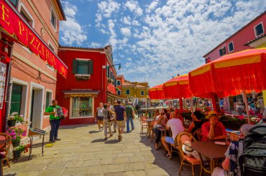 Burano, İtalya - 14 Haziran 2015: Dışarıda eğlenenler, İtalya'da yaz günü, dışarıda şemsiyeli restoranlar