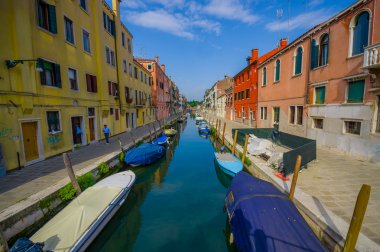 Venedik, İtalya - 18 Haziran 2015: Ünlü Venedik kanalları, evlerin ortasında ki park teknelerinin romantik fotoğrafları