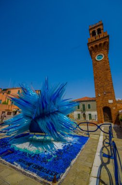 Murano, İtalya - 16 Haziran 2015: Murano Merkezi camına tarafından yapılan mavi yıldız heykel. Arkadaki bir tuğla kulede ile el yapımı işi