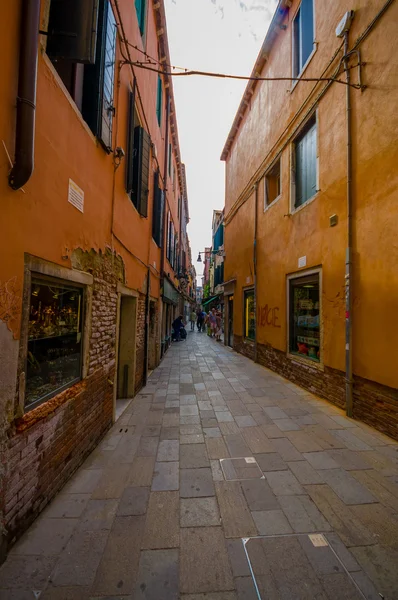 VENICE, ITÁLIA - JUNHO 18, 2015: Veneza ruas estreitas em um bairro pitoresco neigborhood, pessoas que fazem compras nas laterais e turistas que visitam — Fotografia de Stock