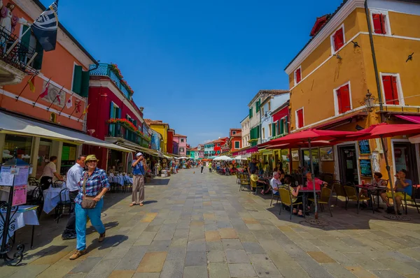 BURANO, ITÁLIA - JUNHO 14, 2015: Rua colorida com casas ao lado de várias cores, turistas desfrutando de verão — Fotografia de Stock