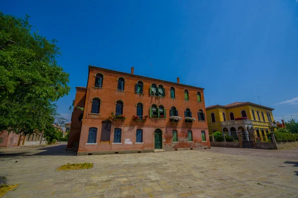 Murano, italien - 16. Juni 2015: schönes und malerisches orangefarbenes Haus in einer Straße von Murano, Fenster geschlossen und niemand draußen — Stockfoto