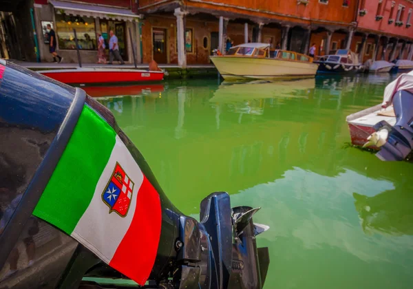 MURANO, ITALIA - 16 DE JUNIO DE 2015: Bandera y escudo de Italia en un motor de barco sobre un agua verde en los canales de Murano — Foto de Stock